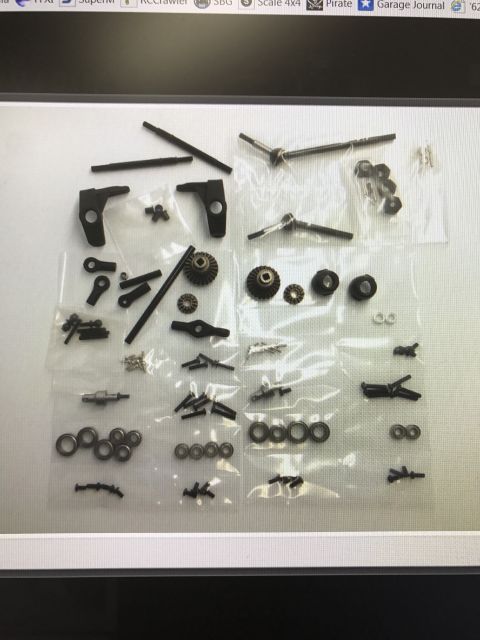 1989 Ford Bronco - Various small parts for an RC car are organized and displayed in clear plastic packaging.