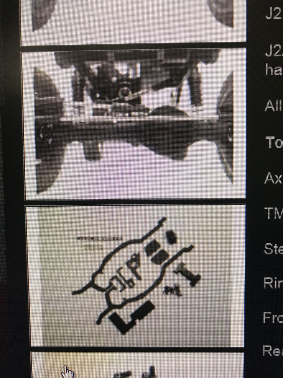 Underside view of a vehicle's chassis and suspension components, including axles and shocks