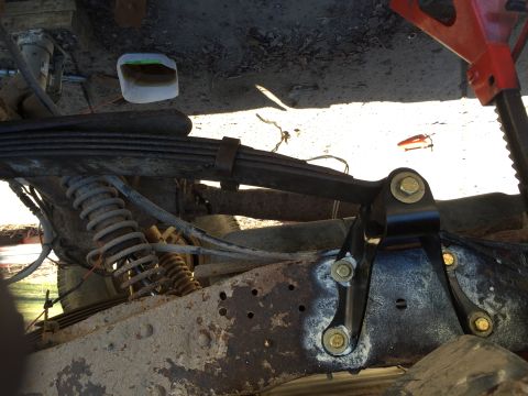 1996 Ford F-150 - The underside of a truck shows its suspension system, including leaf springs and a shock absorber, with visible rust on the frame.