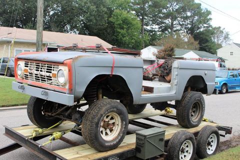 1966 Ford Bronco - This 1966 Ford Bronco is on a trailer, appearing to be in a state of restoration with its gray primer and exposed engine bay.