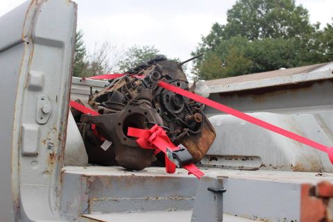 1966 Ford Bronco - Engine and front axle assembly are strapped down in the bed of a vehicle.