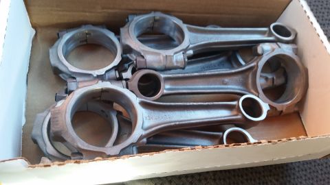1981 Ford Bronco - Several metal connecting rods are neatly arranged in a cardboard box, showing part numbers.