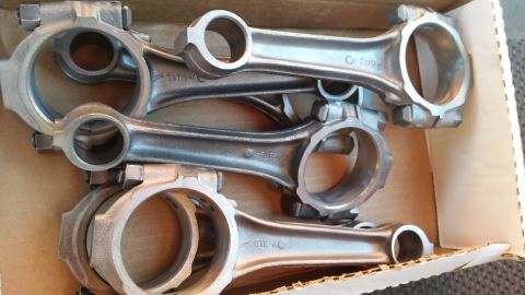 1981 Ford Bronco - Engine connecting rods are shown in a cardboard box. Some have part numbers stamped on them.