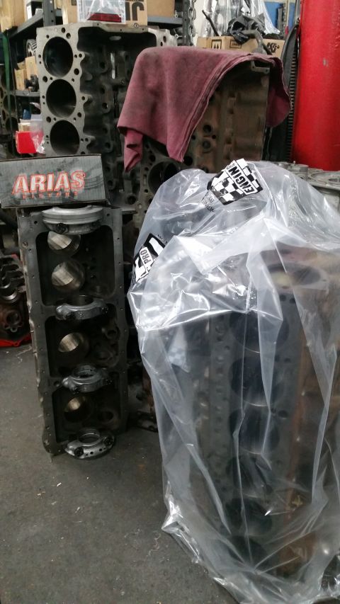 1981 Ford Bronco - Engine blocks are stored in a workshop environment, with one unit wrapped in protective plastic.
