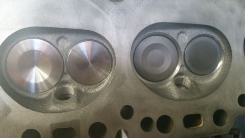1981 Ford Bronco - Close-up view of an engine cylinder head showing two valves, one with a polished surface and the other with a matte finish.
