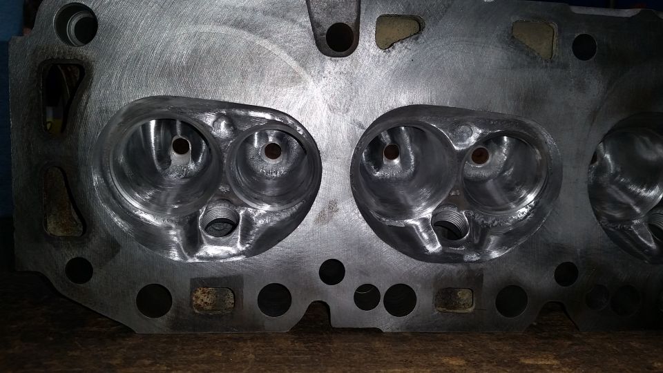 Close-up of a metal engine cylinder head with two large intake ports and two smaller exhaust ports visible