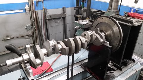 1981 Ford Bronco - A crankshaft is mounted on a balancing machine in a workshop setting.