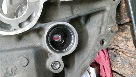 1981 Ford Bronco - A close-up view of a metal engine component, likely a cylinder head or block, with a circular opening revealing internal machinery. The par…