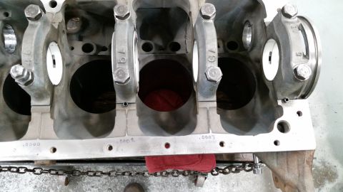 1981 Ford Bronco - Close-up view of a V8 engine block with crankshaft bearing caps installed. The engine block is gray metal with visible markings and bolts.