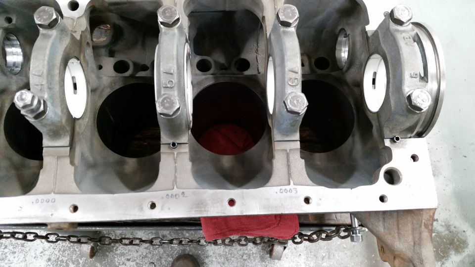 Gray V8 engine block with crankshaft bearing caps installed.