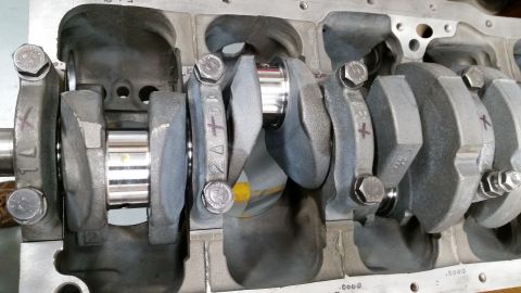 1981 Ford Bronco - A close-up view of a V8 engine's crankshaft and connecting rods within the engine block. The crankshaft journals are polished and appear ne…