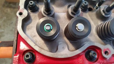 1981 Ford Bronco - A close-up view of the cylinder head of a V8 engine, showing two valve spring assemblies and their retainers. The engine block is painted r…