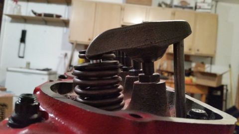 1981 Ford Bronco - A close-up view of a red engine block with valve springs and rocker arms installed. The engine appears to be a V8 with multiple cylinders v…