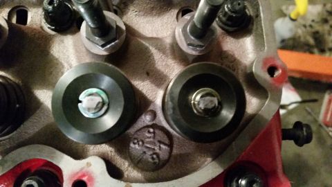 1981 Ford Bronco - A close-up view of the cylinder head of a Ford engine, showing two valve spring retainers and part of the cylinder head casting with stampe…