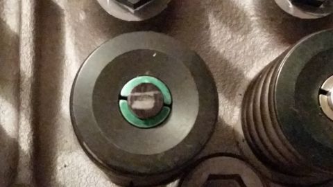 1981 Ford Bronco - A close-up view shows the top of a dark-colored circular automotive part with a green ring around a central opening. The part appears to be…
