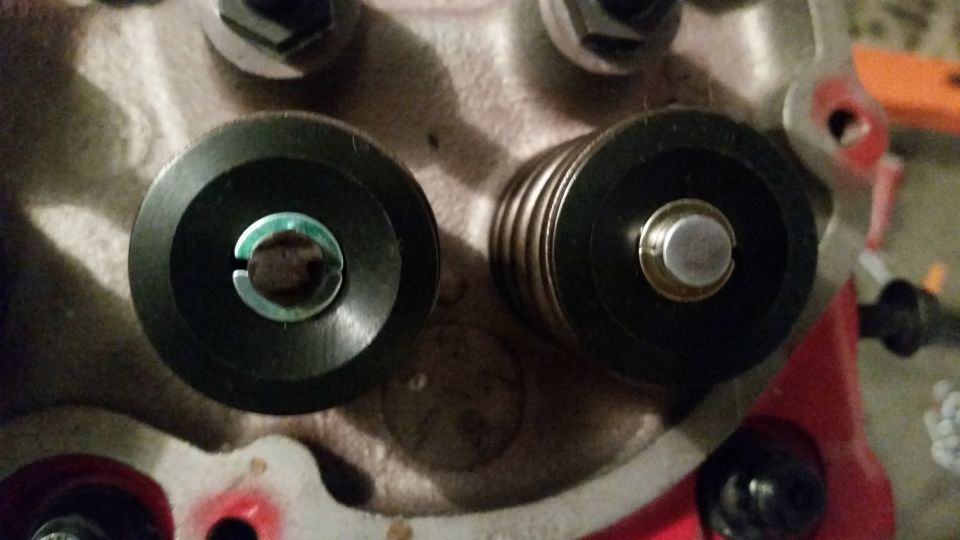 Close-up of two valve spring retainers on an engine cylinder head.