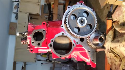 1981 Ford Bronco - A red engine block with two gears attached is shown in a workshop setting. The larger gear has "5A" stamped on it.
