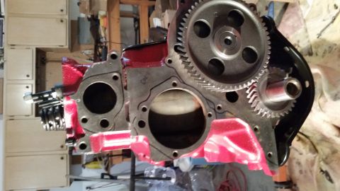 1981 Ford Bronco - A close-up view of a partially assembled engine block, painted bright red, with gears and other internal components visible. The engine blo…