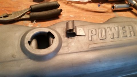 1981 Ford Bronco - A close-up view of a gray, possibly painted, metal engine component with the word "POWER" embossed on its surface. A metal clip is attached…