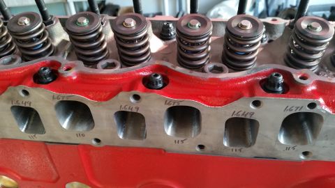 1981 Ford Bronco - Close-up view of a red engine block with valve springs and intake ports. Markings on the intake ports indicate measurements like "1.649", "…