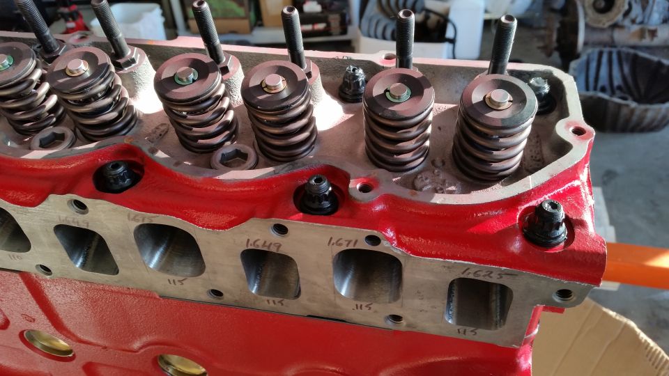 Close-up of a red engine block with valve springs and intake ports.