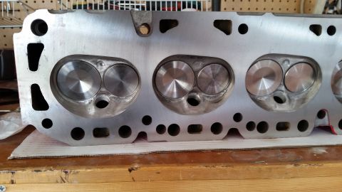 1981 Ford Bronco - A close-up view of the intake and exhaust ports of a V8 engine cylinder head, likely from a Ford vehicle, showing the machined surfaces and…