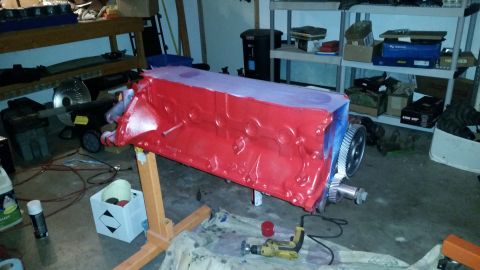 1981 Ford Bronco - A red engine block is mounted on an orange engine stand in a garage setting. The engine block appears to be freshly painted and has a large…