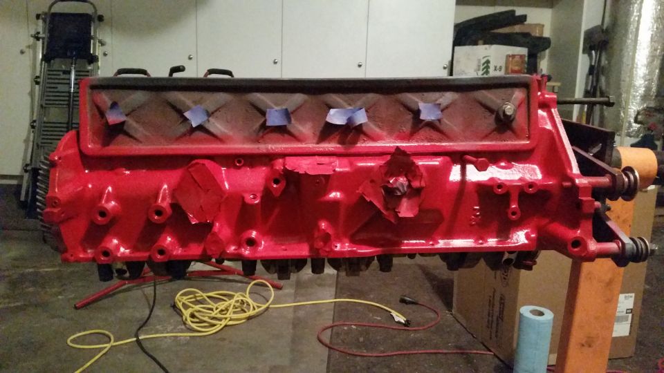 Red engine block on an engine stand in a garage