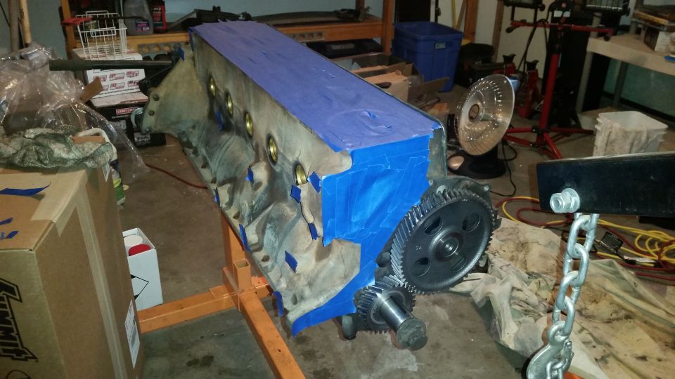 Engine block on stand with blue tape and gears.