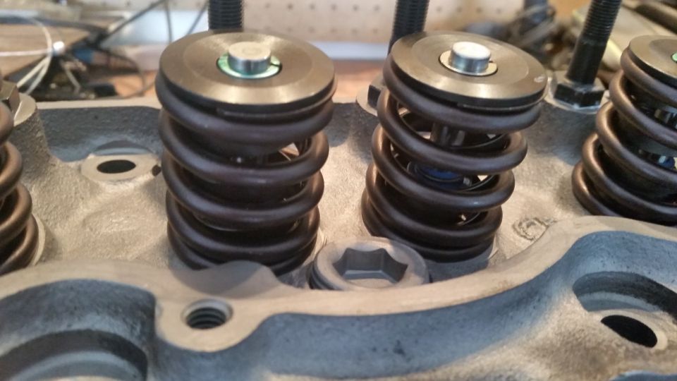 Close-up of engine cylinder head with valve springs and retainers.
