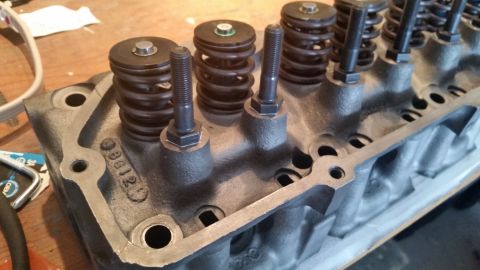 1981 Ford Bronco - Close-up view of a cast iron cylinder head with multiple valve springs and retaining hardware installed. The head has a casting number visi…