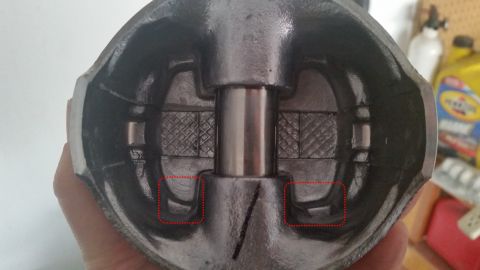 1981 Ford Bronco - This is a close-up, interior view of a piston, likely from a vehicle engine. The piston is made of dark metal and features two distinct cut…