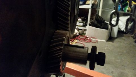 1981 Ford Bronco - A close-up, side view of a large gear with a bolt and adapter attached. The gear appears to be part of a vehicle's drivetrain.