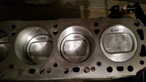 1981 Ford Bronco - This is a close-up, straight-on view of a V8 engine block with three pistons installed. The pistons are marked with "4.029" and part number…