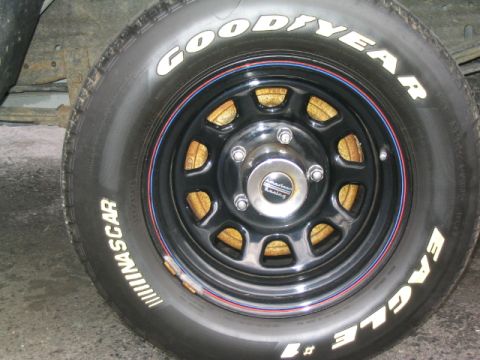 1996 Ford F-150 - This image shows a close-up of a Goodyear Eagle NASCAR tire mounted on a black American Racing wheel, with visible brake components behind…