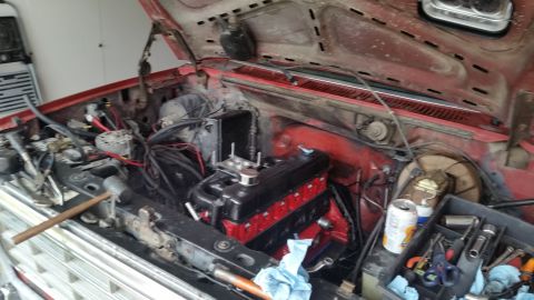 1981 Ford Bronco - Tools and a can of soda are visible in the engine bay of a red vehicle.