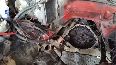 1981 Ford Bronco - The engine bay shows exposed transmission components and a tangle of wires and hoses.
