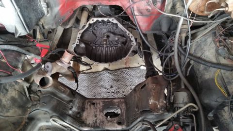 1981 Ford Bronco - Vehicle engine bay with transmission removed, showing the bell housing and surrounding components.