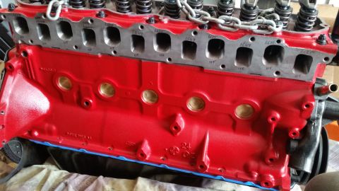 1981 Ford Bronco - Close-up of a red V8 engine block, likely undergoing rebuild or restoration.