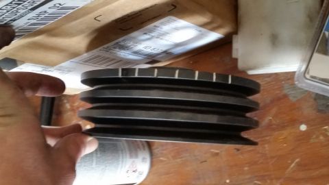 1981 Ford Bronco - A black multi-groove pulley is held in a person's hand, with packaging and other items in the background.