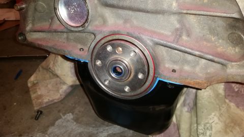 1981 Ford Bronco - Close-up of an engine component, likely a crankshaft seal area with an oil pan attached.