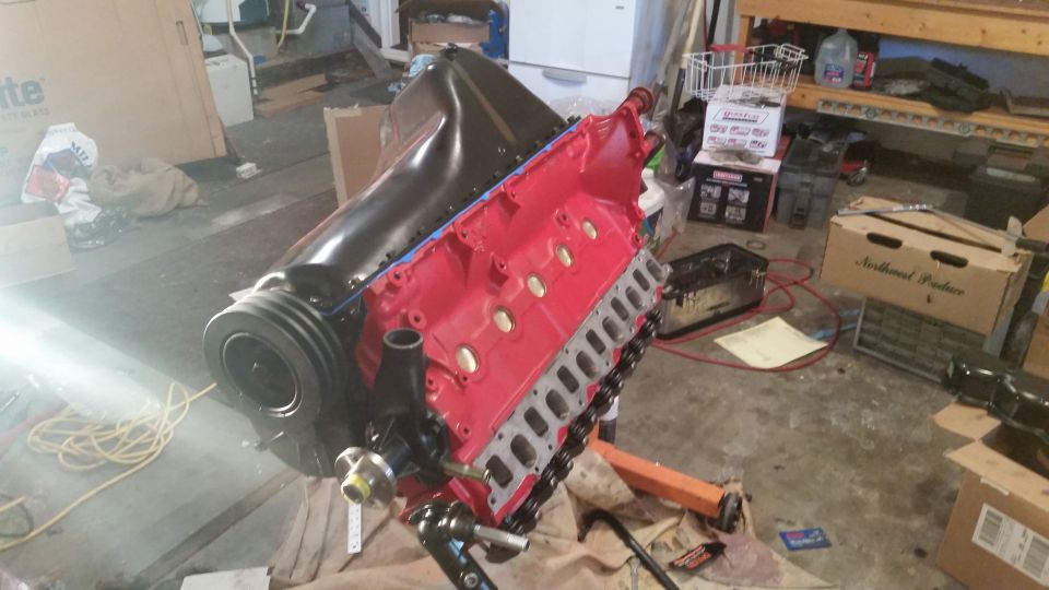 Red V8 engine on stand, black intake manifold, black valve covers