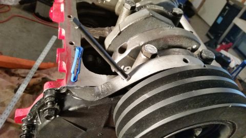 1981 Ford Bronco - Close-up view of an engine's crankshaft pulley, showing its ribbed design and a bolt securing a component to the engine block.