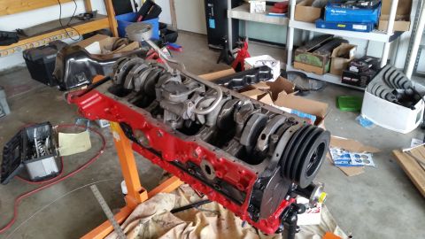 1981 Ford Bronco - Engine block assembly on a stand in a cluttered garage environment.
