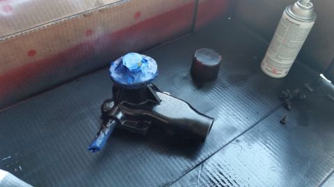 1981 Ford Bronco - A brake master cylinder is prepared for painting, with masking tape protecting sensitive areas.
