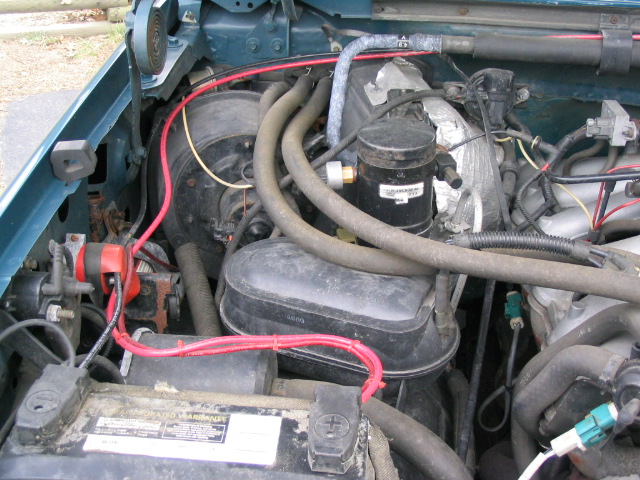 Engine bay of a 1996 Ford F-150, showing battery and various engine components