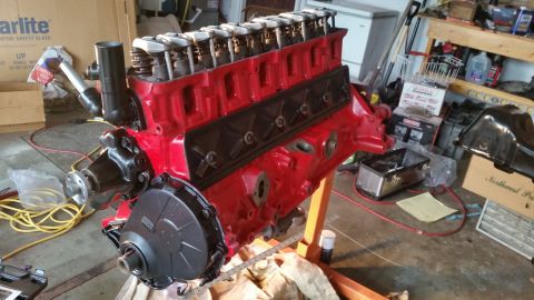 1981 Ford Bronco - A red V8 engine is mounted on an engine stand in a garage setting.