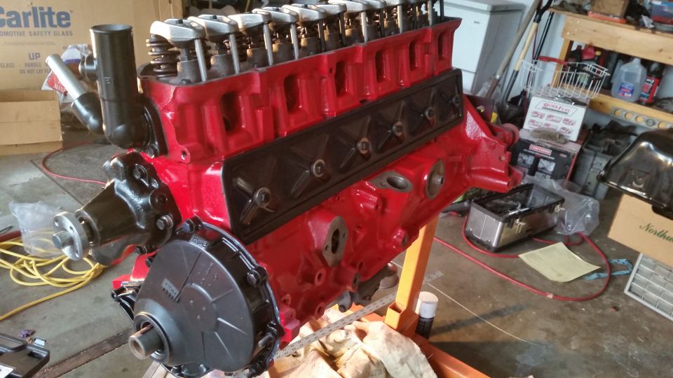 Red V8 engine on an orange engine stand, viewed from the side