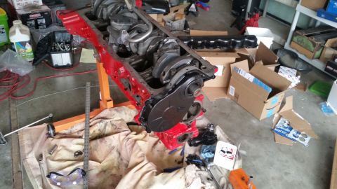 1981 Ford Bronco - Engine block assembly on an engine stand in a garage setting with various tools and parts.