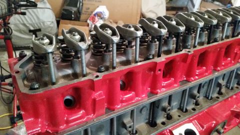 1981 Ford Bronco - Close-up view of a red engine cylinder head, showing internal components like rocker arms and valve springs.